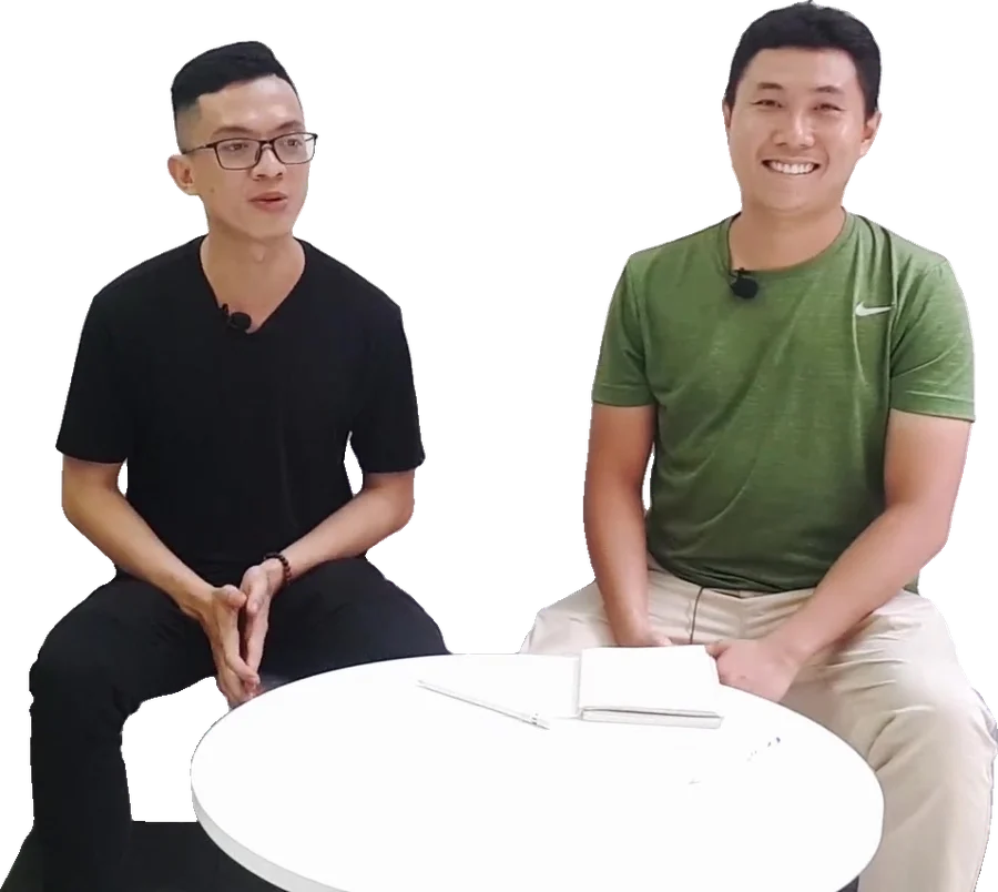 Hai người ngồi sofa cười tươi bên bàn tròn